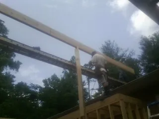 Carpenter setting a ridge beam over a new addition frame — Ice Dam Removal by Roofing Brothers in East Dubuque