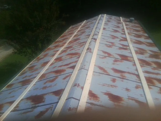 Rusted metal roof panels with new wood purlins before replacement — Storm Damage Roof Repair in East Dubuque by Roofing Brothers