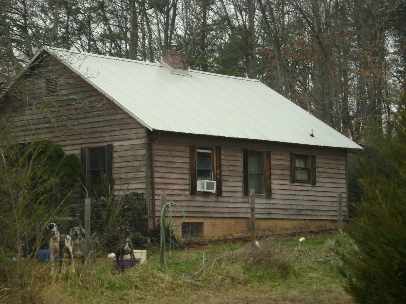 White metal roof on an old wood sided farmhouse, from a Metal Roof Installation job in East Dubuque